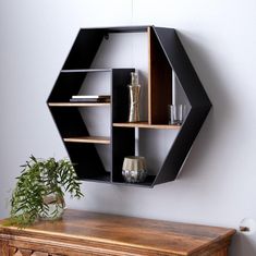 a wooden table topped with a shelf next to a potted plant on top of it