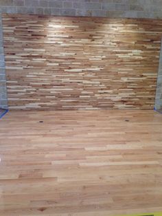 an empty room with hard wood flooring being installed on the walls and around it