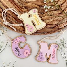 two decorated cookies sitting on top of a table next to a basket filled with flowers