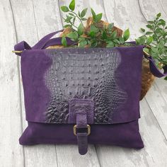 This snake print style bag comes in black or purple. has been made in Italy from quality, soft suede leather and has a long 60cm adjustable strap which makes it an ideal crossover body bag. It is a fully lined bag with one internal zip pocket. It also has a zip pocket on the rear of the bag. Full features of this beautiful bag, include: * Flap Over Zipper, which is great for security * Closure on top * Old gold tone metal hardware * Outer back zipped pocket * Internal zipped pocket * Snake skin detail on front * Soft Real Suede leather * Fully lined inside * Handle drop: 60cm * Dimensions: H28cm x W29cm x D4cm * Material: leather and mixed metals This suede bag has been made in Italy by artisans from genuine suede and the quality is clear to see. Due to the individual nature, the shade of Purple Leather Rectangular Bag, Purple Leather-handled Crossbody Bag, Purple Leather Bag For Daily Use, Purple Leather Shoulder Bag With Adjustable Strap, Purple Leather Shoulder Bag For Everyday, Everyday Purple Leather Shoulder Bag, Purple Leather Bags With Removable Pouch, Purple Leather Satchel With Removable Pouch, Purple Leather Satchel Bags