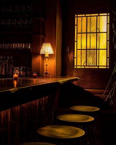 a bar with stools in front of a window