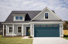 a gray and white house with blue garage doors