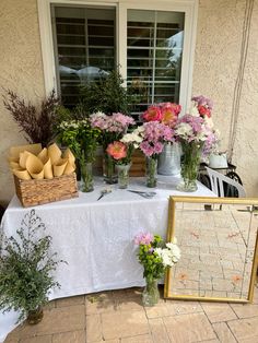 a table topped with vases filled with flowers next to a window