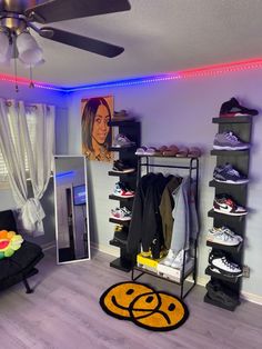 a room that has some shoes on shelves and a fan in the corner with lights