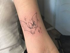 a small bat tattoo on the arm