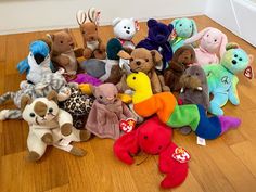 a pile of stuffed animals sitting on top of a wooden floor