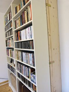 a bookshelf filled with lots of books next to a wall mounted book shelf