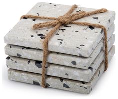 four white and black coasters tied up with twine on each one, sitting in front of a white background