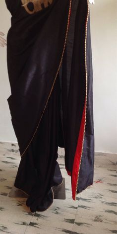 "Stylish black semi silk saree with intricate elephant hand embroidery and raw silk unstiched blouse in red with matching elephant embroidery at the sleeves. This is a unique one of a kind piece and the zardosi work is truly beautiful. Saree length 5.5 meters Blouse fabric 1 meter 44\" wide Saree is custom made and ships out in 2 weeks time.Shipping time is 4-5 days with tracking. We also offer blouse and petticoat stitching for saree as additional services. Please convo me if you need help or h Bollywood Style Black Cotton Silk Pre-draped Saree, Black Cotton Silk Pre-draped Saree For Diwali, Black Silk Blouse Piece With Zari Work, Designer Art Silk Black Blouse Piece, Designer Black Katan Silk Blouse Piece, Designer Black Art Silk Blouse Piece, Black Katan Silk Blouse For Designer Wear, Black Silk Saree With Zari Work, Black Silk Fitted Saree