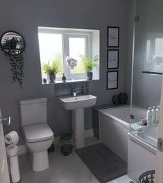 a bathroom with a sink, toilet and bathtub next to a window in it