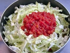 lettuce and tomato sauce in a bowl on the counter top, ready to be cooked