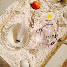 an assortment of ingredients are laid out on the counter for making cake batter, including eggs and flour