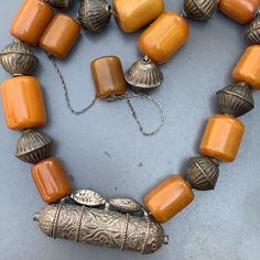 Vintage Bedouin / Yemeni pendant /amulet / hirz necklace with large Butterscotch Amber beads with hollow silver plated ribbed beads in between . Unsigned /unmarked ...Bakelite tested for simichrome and are beautifully aged with variation/ darkening of color on the edges which would only come with age and exposure to heat and light. Materials : Bakelite silver plated or very lower grade silver metal Measures : Total necklace is 37 inches in length x 7/8 inches max width ( Somebody has added the b Vintage Amber Necklaces For Festivals, Antique Amber Jewelry With Large Beads, Carved Amber Amulet Jewelry, Antique Amber Necklaces With Polished Beads, Antique Amber Necklace With Polished Beads, Bohemian Carved Amber Jewelry, Amulet Style Necklaces With Large Pendant And Round Beads, Traditional Amber Jewelry With Carved Details, Antique Necklaces With Large Beads For Gift