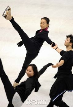 three people in black outfits are doing tricks on ice skates while one woman is holding her leg up