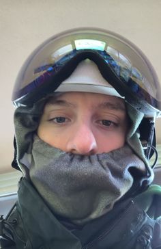 a young boy with goggles on his face is wearing a hood and looking at the camera