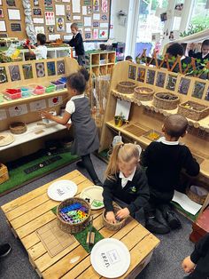 children sitting on the floor playing with toys in a room full of books and pictures