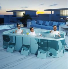 three children are sitting in an outdoor hot tub with blue couches and pillows behind them