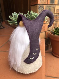 a purple and white gnome planter with succulents