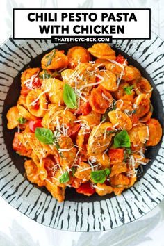 a bowl filled with pasta and chicken covered in sauce, parmesan cheese and basil