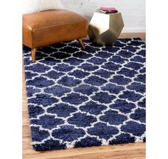 a blue rug with white trellis on it in front of a brown leather chair