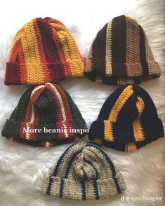 four knitted hats sitting on top of a white furnishing floor next to each other