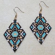 a pair of beaded earrings sitting on top of a table