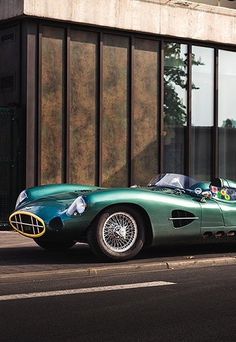 a green sports car parked in front of a building