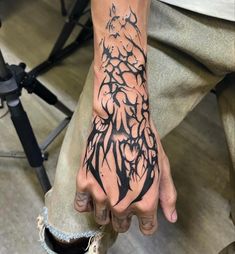 a man's hand with black ink on it and an intricate design in the middle