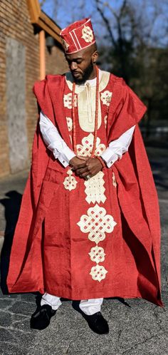 A Red hand woven Silk Cotton Blend Robe with unique embroidery patterns. This regal Agbada Grandboubou will get you looking like the royalty that you are.  Inner Dashiki Top and Pants sold separately Beaded Necklaces and bracelet sold separately Please include in comment if you would like a free hat. Hat price is not included in price of item. Unfortunately, we cannot guarantee what size we have available. Handwoven, Silk and Cotton Blend Dry clean only Length approximately 55" long Embroidery only along neckline at the back of the robe African Dashiki Shirt, African Tops For Women, Agbada Design, African Pants, African Suit, African Hats, Dashiki Shirt, African Tops, Head Wraps For Women