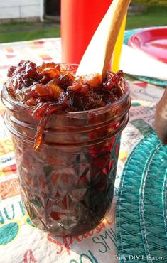 a jar filled with food sitting on top of a table next to a red cup