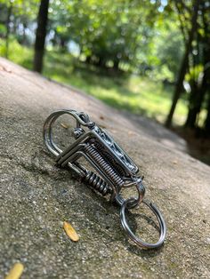 a small metal object sitting on top of a cement surface next to trees and leaves