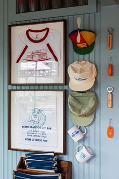 there are many hats and other items on the wall in this room, including t - shirts