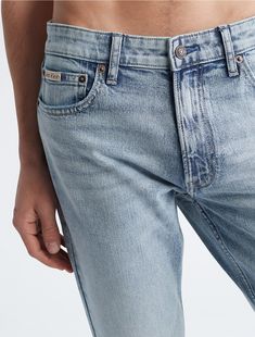 An iconic essential, our reimagined jeans are made with flexible stretch denim for enhanced movement and all-day comfort. Updated with signature metal logo hardware, a Calvin Klein hallmark. Cut in a slim fit with considered detailing and reinforced seams.  Material: Forever Black Wash. Flexible Stretches, Iconic Logo, Metal Logo, Light Wash Jeans, Wash Jeans, Metallic Logo, Slim Fit Jeans, Stretch Denim, Cotton Material