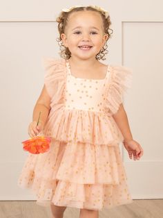 Add a touch of whimsy to your little one's wardrobe with our Soft Blush Sparkle Tiered Tulle Dress. Designed specially for MNC, this girls' dress features delicate tiers of tulle in a soft blush color, sprinkled with subtle gold sparkles for a touch of magic. Perfect for the special dates on your social calendar! Ship the matching bubble! Fits true to size. 95% Polyester / 5% Spandex Combo: 100% Polyester Accessories sold separately. Suggest bow color #1 and #46 Import. Aurora is 30 inches tall and 25 lbs wearing size XS 18-24 months. **Afterpay and Sezzle Purchase Requires $35 Minimum Order. Summer Princess Dress With Ruffles And Tiered Shape, Whimsical Summer Tutu Dress For Playtime, Summer Princess Dress With Ruffles For First Birthday, Playful Ruffled Tutu Dress For Dress-up, Spring Princess Dress With Ruffles For First Birthday, Summer Princess Tiered Dress, Cute Summer Princess Dress For First Birthday, Summer Tiered Princess Dress, Princess Style Flutter Sleeve Dress