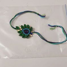 a green and blue necklace on a plastic bag