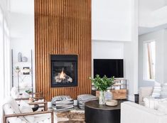 a living room filled with furniture and a fire place next to a wall mounted tv