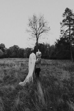 a bride and groom standing in the middle of a field