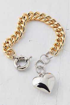 Mixed in gold and silver, this chunky chain bracelet is trimmed with an oversized heart charm. Features Metal heart chain bracelet Chunky chain bracelet Mixed metal design Polished metal heart charm Adjustable closure Content + Care Mixed metal Avoid contact with water Imported Size Dimensions: 7.5" l | Metal Heart Chain Bracelet in Assorted, Women's at Urban Outfitters Trendy Gold Heart Bracelet With Chain, Metal Heart Charm Bracelet With Adjustable Chain, Heart-shaped Metal Charm Bracelet With Adjustable Chain, Metal Heart Chain Bracelet For Valentine's Day, Metal Heart Bracelet With Chain, Trendy Metal Heart Charm Bracelet, Heart-shaped Metal Bracelet With Chain, Metal Chain Link Jewelry With Heart Charm, Trendy Metal Chain Bracelet With Heart Charm