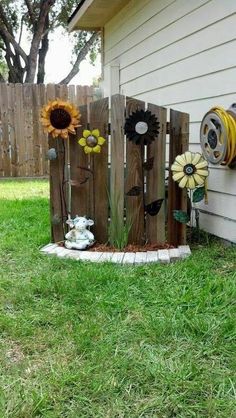 a wooden fence with sunflowers and other decorations on it