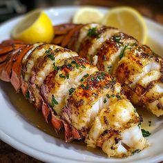 lobster and crab on a plate with lemon wedges