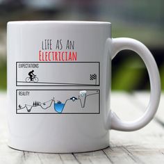 a white coffee mug with the words life as an electrician on it sitting on a wooden table