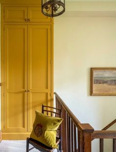 a room with yellow painted walls and wooden stairs