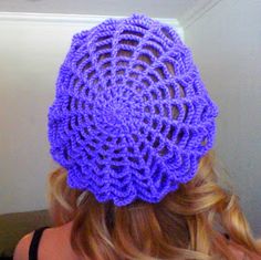 there is a purple crochet hat on top of a woman's head