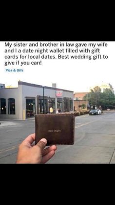 someone is holding up a wallet on the street with an ad in front of them