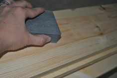 a person sanding wood with a sponge