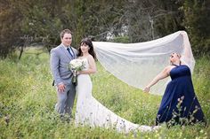 a bride and groom standing in the tall grass