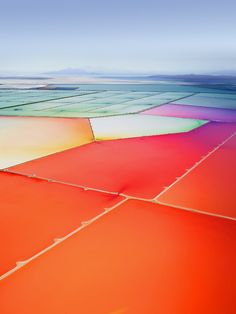 an aerial view of the vast expanses of water and land that is covered in bright colors