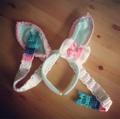 two crocheted bunny ears and one with a pink bow on the headband