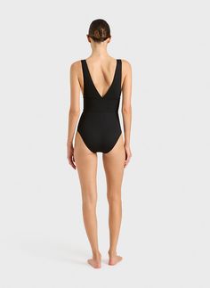 The Victoria One Piece in black is one of best sellers as it is extremely flattering and comfortable to wear. Made from a single layer of our Italian engineered Singuleur fabric® that uses an advanced flexion technology to envelope the body like a second skin. The deep plunge V neckline front and back sits above a wide band that provides support under the bust whilst contouring and flattering the waistline. Comfortable wide shoulder straps move with the body and stay safe in the water. A timeles Black Compressive Functional Swimwear, Sleek Black Swimwear With Seamless Construction, Functional Fitted Black Swimwear, Sleek Black Seamless Swimwear, Modern Fitted Black Swimwear, Compressive Seamless Black Swimwear, Sleek Black Second-skin Swimwear, Modern Black Swimwear With Minimal Stretch, Modern Black Swimwear