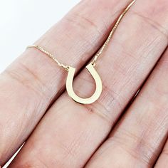 This stunning horseshoe gold necklace is a perfect symbol of good luck and charm. The pendant is crafted from high-quality 14k gold and features a beautifully designed horseshoe with intricate detailing that catches the eye. The pendant hangs on a dainty yet sturdy gold chain that complements the pendant's design, creating an elegant and timeless piece of jewelry. This necklace is perfect for adding a touch of equestrian style to any outfit, and is a must-have for any horse lover, cowgirl, or co Horseshoe Necklace Gold, Cowgirl Necklaces, Western Necklace, Jewelry Western, Lucky Charm Necklace, Western Necklaces, Horseshoe Necklace, Equestrian Jewelry, Photo Pendant